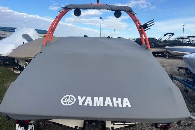 Slide: The Image of 2019 Yamaha AR190 boat with cover, featuring red wakeboard tower, parked outdoors. - 36