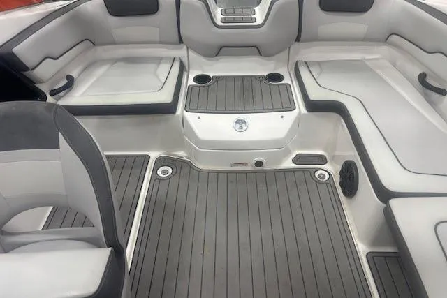 Slide: The Image of 2019 Yamaha Boats AR190 interior with gray seating and flooring, featuring cup holders. - 49