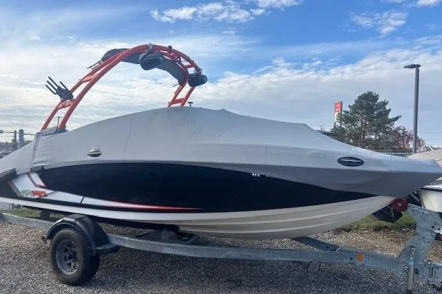 Slide: The Image of 2019 Yamaha Boats AR190 covered on trailer, with red wakeboard tower, under a cloudy sky. - 5
