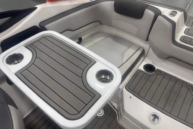 Slide: The Image of 2019 Yamaha Boats AR190 interior with seating and table, featuring cup holders. - 52