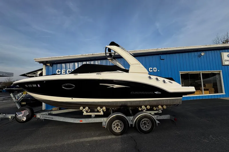 The Image of 2019 Chaparral 246 SSi boat on trailer, parked outside a blue building. - 0