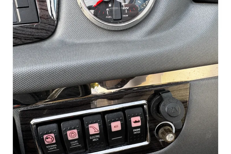 Slide: The Image of Dashboard controls of a 2019 Chaparral 246 SSi boat with switches and 12V outlet. - 13