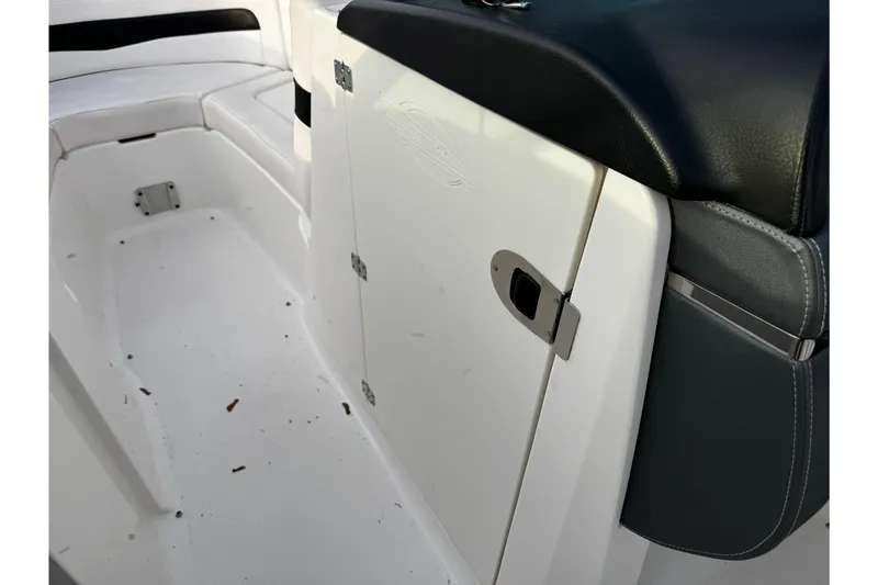 Slide: The Image of 2019 Chaparral 246 SSi boat interior with white seating and storage compartment. - 19