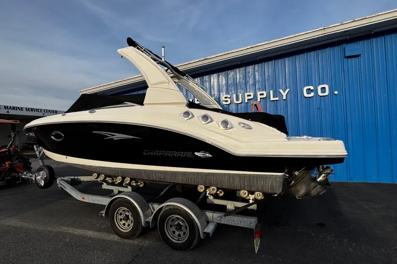 Slide: The Image of 2019 Chaparral 246 SSi boat on trailer outside blue building. - 2