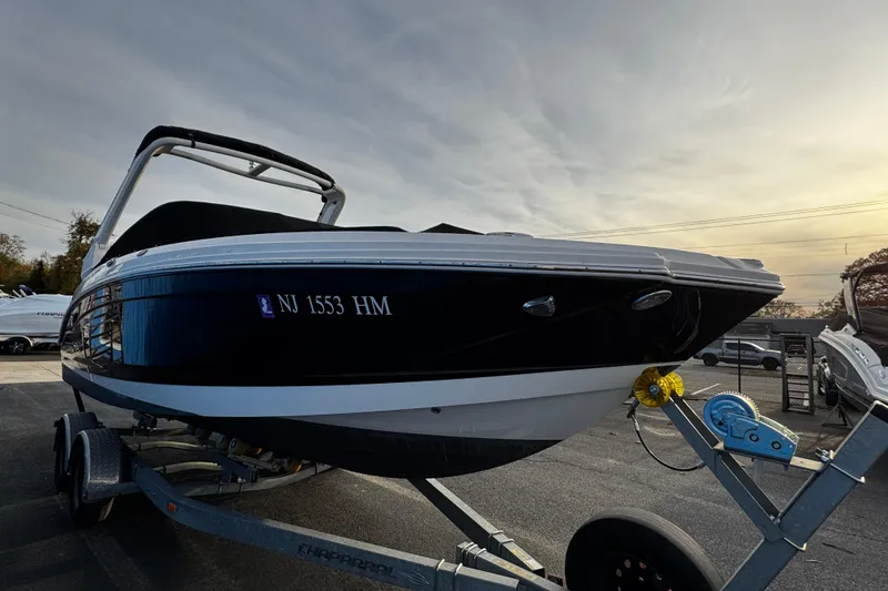 Slide: The Image of 2019 Chaparral 246 SSi boat on trailer, black and white exterior, parked outdoors. - 4