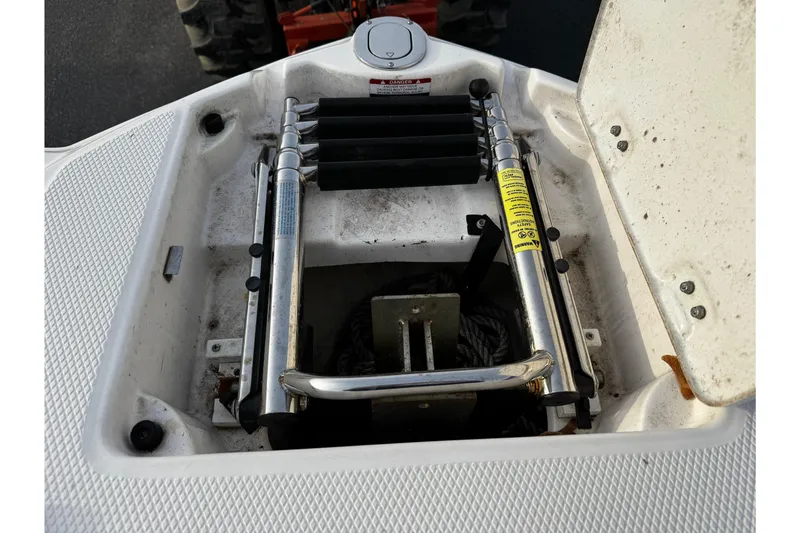 Slide: The Image of 2019 Chaparral 246 SSi boat ladder compartment with open hatch and visible ladder. - 40