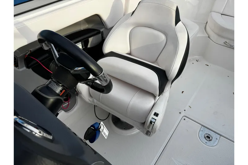 Slide: The Image of 2019 Chaparral 246 SSi boat interior with steering wheel and white captain's seat. - 43