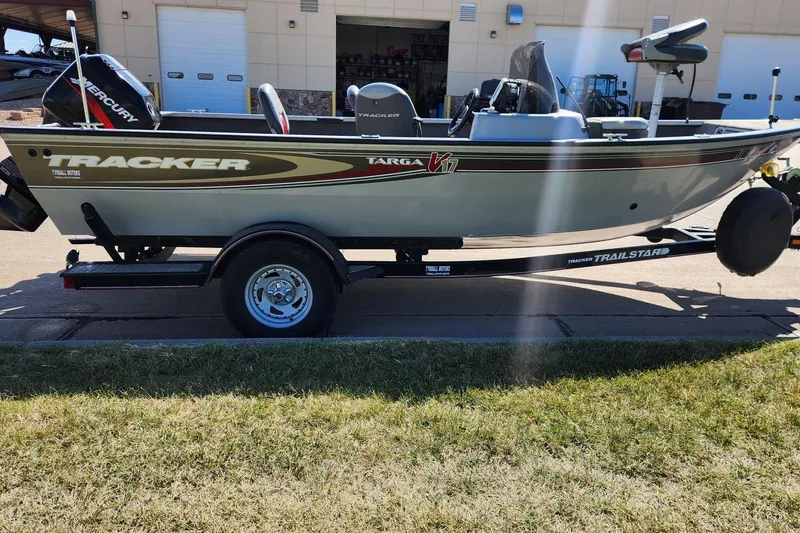 Slide: The Image of 2005 Tracker Targa 17 boat on trailer, parked outdoors near a building. - 5