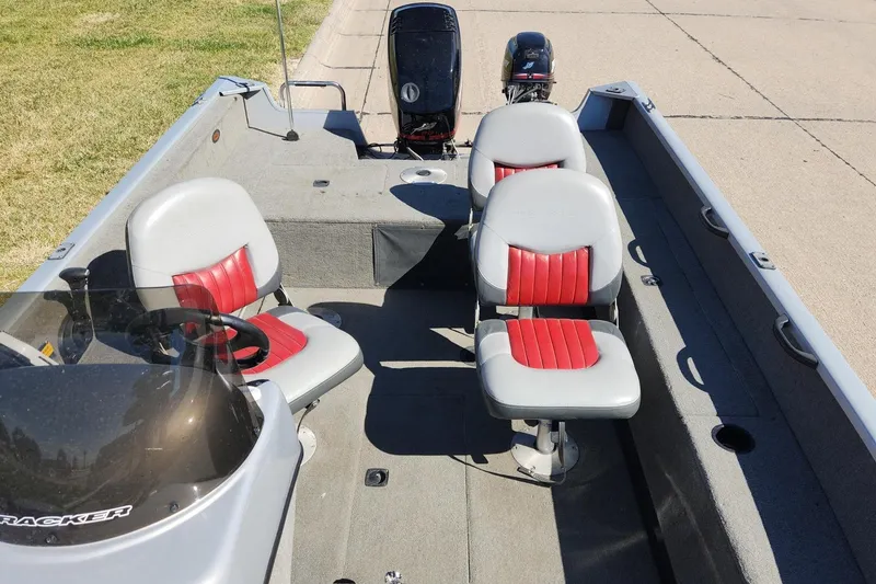 Slide: The Image of 2005 Tracker Targa 17 boat interior with red and gray seating, steering wheel, and motor. - 7