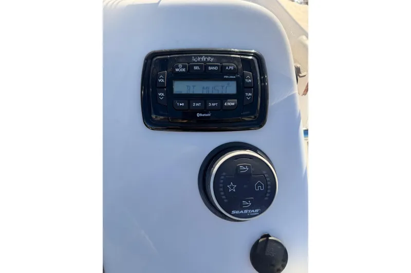 Slide: The Image of 2022 Sea Chaser 21 Sea Skiff dashboard with Infinity stereo and SeaStar controls. - 11
