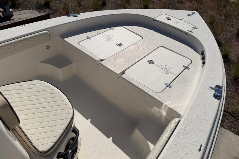 Slide: The Image of 2022 Sea Chaser 21 Sea Skiff boat interior with cushioned seating and storage compartments. - 15