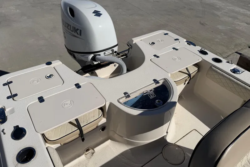 Slide: The Image of 2022 Sea Chaser 21 Sea Skiff boat with Suzuki outboard motor, featuring storage compartments. - 17