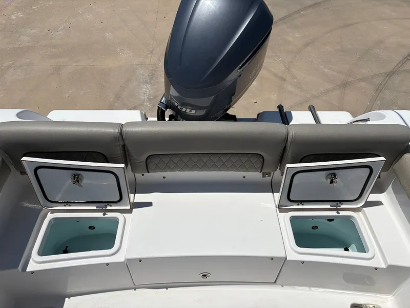 Slide: The Image of 2021 Sportsman Heritage 241 Center Console boat with open storage compartments and motor. - 13