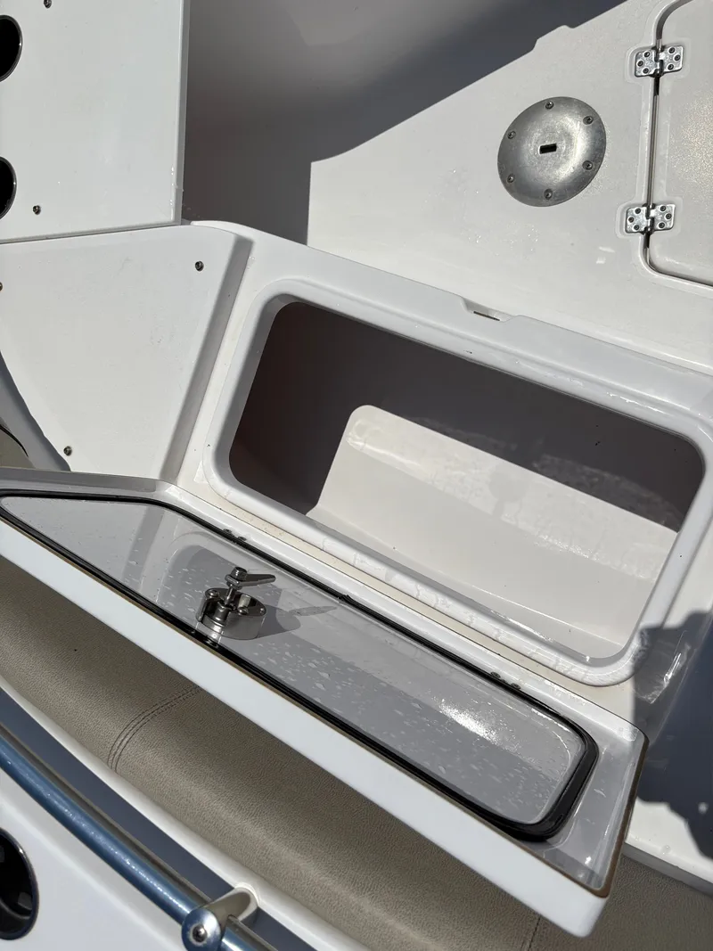 Slide: The Image of 2021 Sportsman Heritage 241 Center Console storage compartment with open lid and latch. - 29