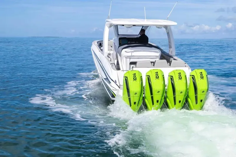 Slide: The Image of 2026 Deep Impact 399 Sport boat with four green outboard motors cruising on open water. - 28