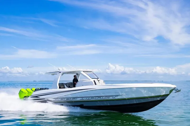 Slide: The Image of 2026 Deep Impact 399 Sport boat cruising on clear blue water under a sunny sky. - 29