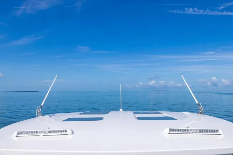 Slide: The Image of Bow of 2026 Deep Impact 399 Sport boat on calm ocean under clear blue sky. - 40