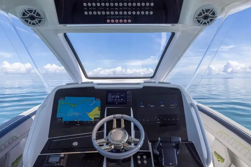 Slide: The Image of Helm of 2026 Deep Impact 399 Sport boat with navigation screens and ocean view. - 45