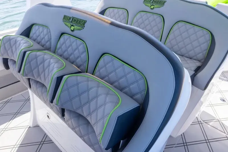 Slide: The Image of 2026 Deep Impact 399 Sport boat seats with quilted design and green accents. - 49