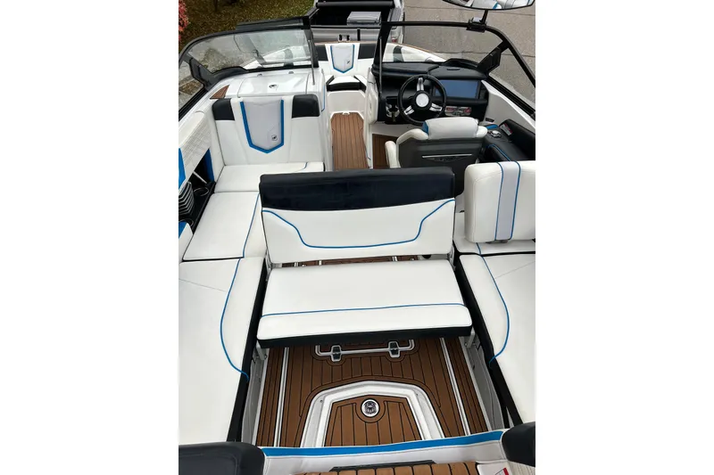 Slide: The Image of 2019 Nautique Super Air Nautique G21 interior with white and blue seating, wooden flooring. - 11