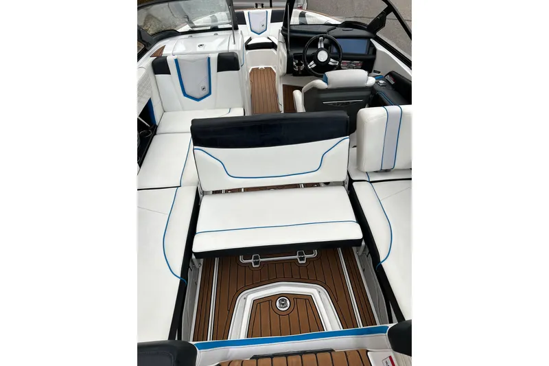 Slide: The Image of 2019 Nautique Super Air Nautique G21 interior with white and blue seating, wooden flooring. - 13