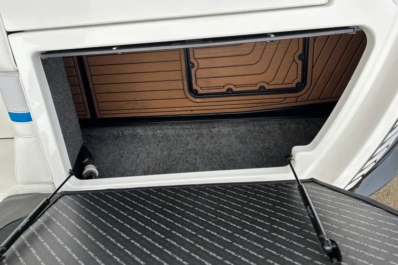 Slide: The Image of 2019 Nautique Super Air Nautique G21 storage compartment with open hatch and carpeted interior. - 17