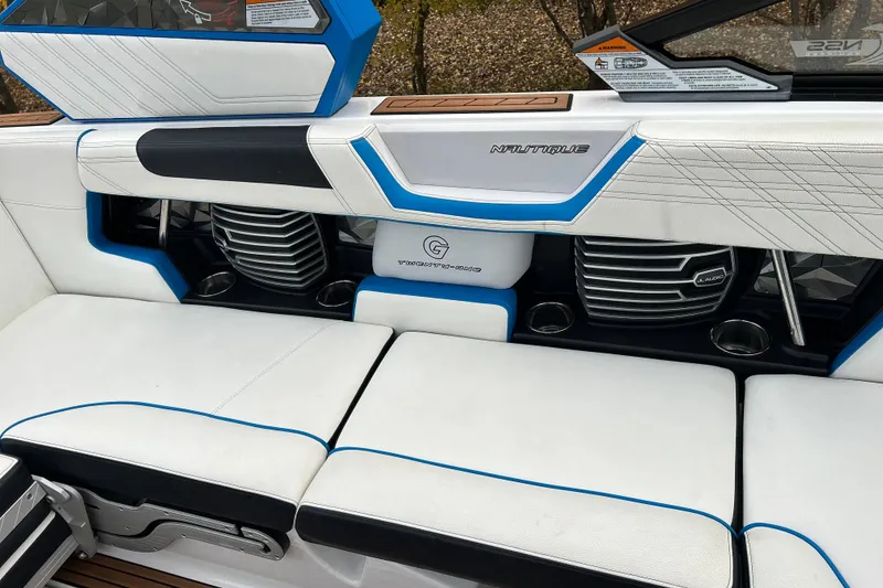 Slide: The Image of 2019 Nautique Super Air Nautique G21 interior with white and blue seating and JL Audio speakers. - 18