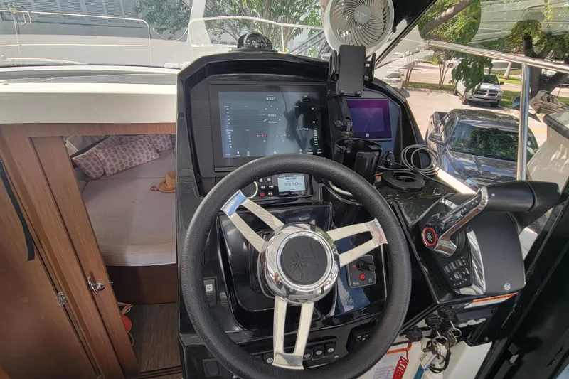 Slide: The Image of 2023 Jeanneau NC 895 helm with modern navigation controls and cozy cabin view. - 16