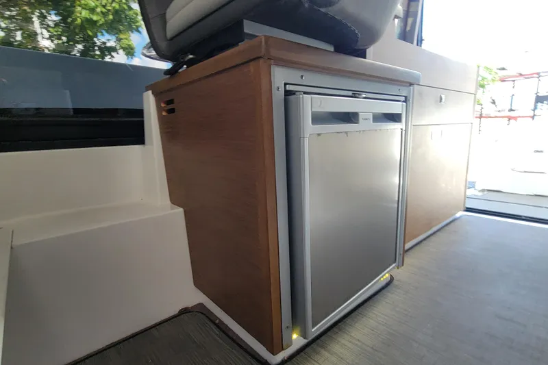 Slide: The Image of Interior of 2023 Jeanneau NC 895 boat featuring a compact refrigerator. - 17