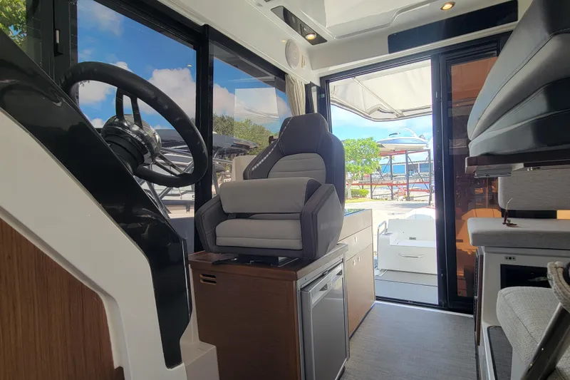 Slide: The Image of Interior of 2023 Jeanneau NC 895 boat, featuring helm and seating area. - 19