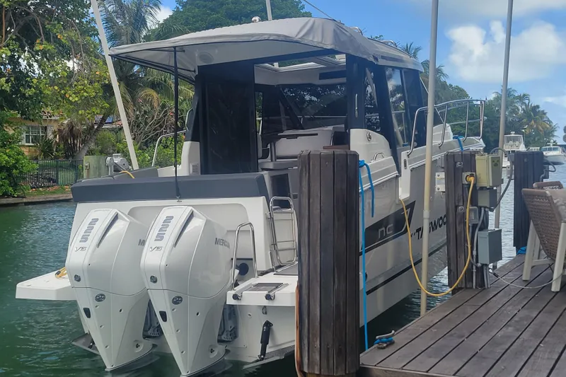 Slide: The Image of 2023 Jeanneau NC 895 boat docked with twin Mercury outboard engines. - 33