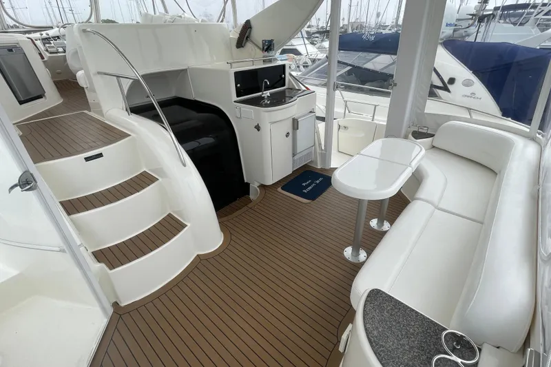 Slide: The Image of 2006 Meridian 459 Motoryacht interior with white seating, kitchenette, and wooden flooring. - 13