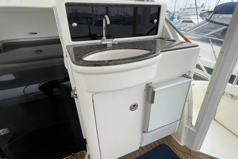 Slide: The Image of 2006 Meridian 459 Motoryacht kitchenette with sink and mini fridge, docked at marina. - 14