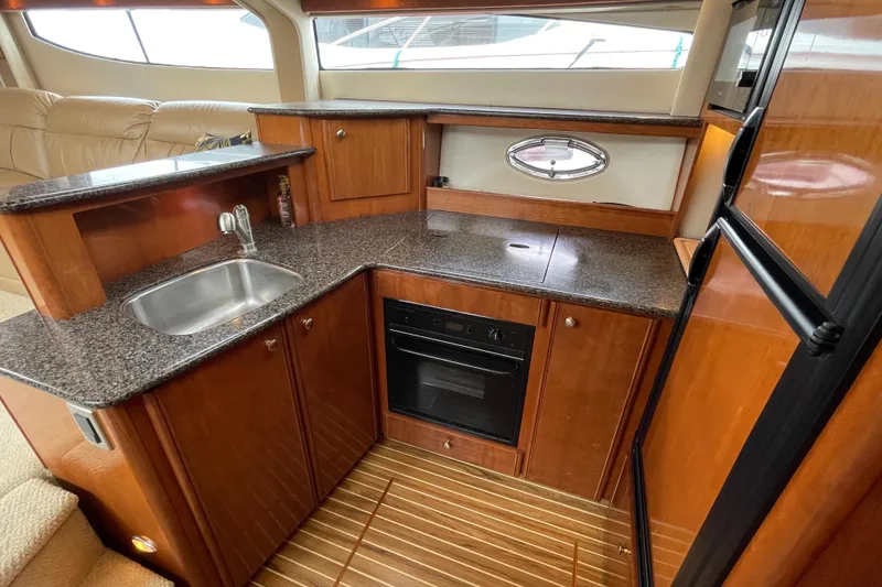 Slide: The Image of 2006 Meridian 459 Motoryacht kitchen with wood cabinetry, granite countertops, and stainless steel sink. - 27