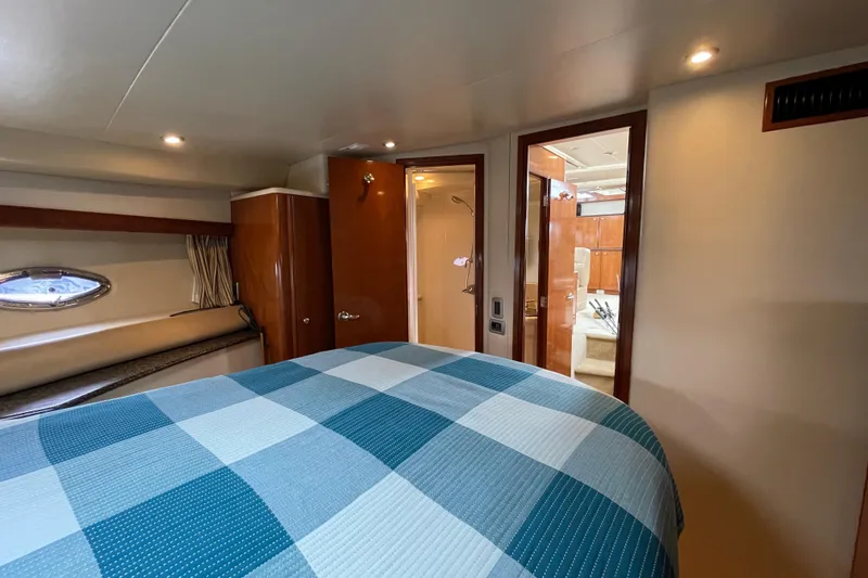 Slide: The Image of Interior of 2006 Meridian 459 Motoryacht bedroom with checkered bedding and wooden accents. - 35