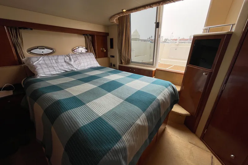 Slide: The Image of Luxurious bedroom interior of 2006 Meridian 459 Motoryacht with plaid bedding and porthole windows. - 40
