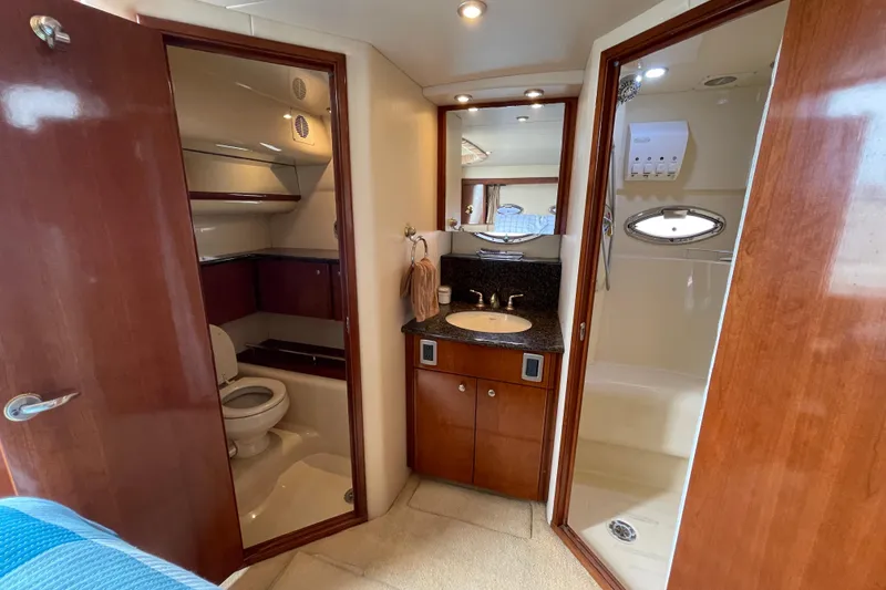 Slide: The Image of 2006 Meridian 459 Motoryacht bathroom with toilet, sink, and shower. Luxurious wood finish. - 46