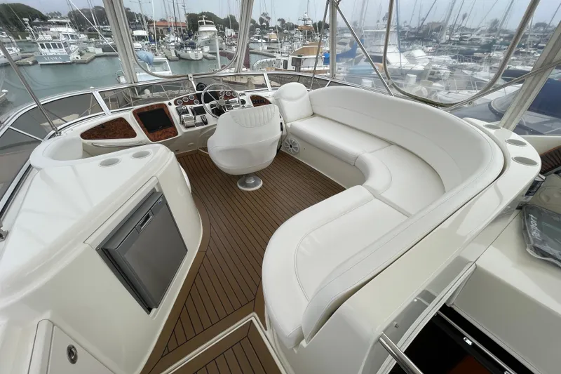 Slide: The Image of 2006 Meridian 459 Motoryacht interior with white seating and wood flooring in a marina setting. - 47