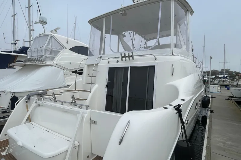 Slide: The Image of 2006 Meridian 459 Motoryacht docked at marina, featuring sleek design and spacious deck. - 5