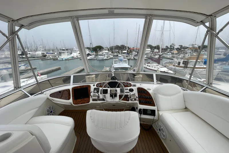 Slide: The Image of Luxurious 2006 Meridian 459 Motoryacht helm with marina view, featuring plush seating and modern controls. - 50