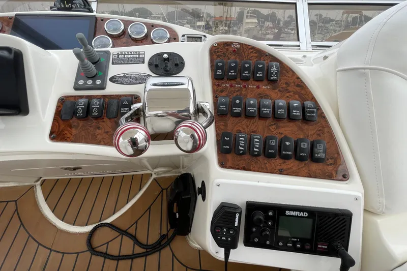 Slide: The Image of Control panel of a 2006 Meridian 459 Motoryacht with various switches and navigation equipment. - 52