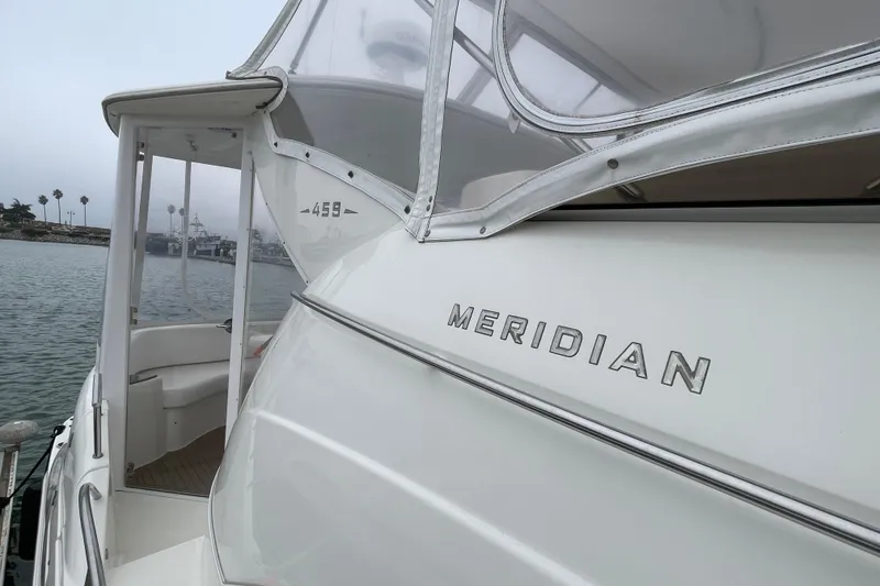 Slide: The Image of 2006 Meridian 459 Motoryacht docked, showcasing sleek design and branding. - 59