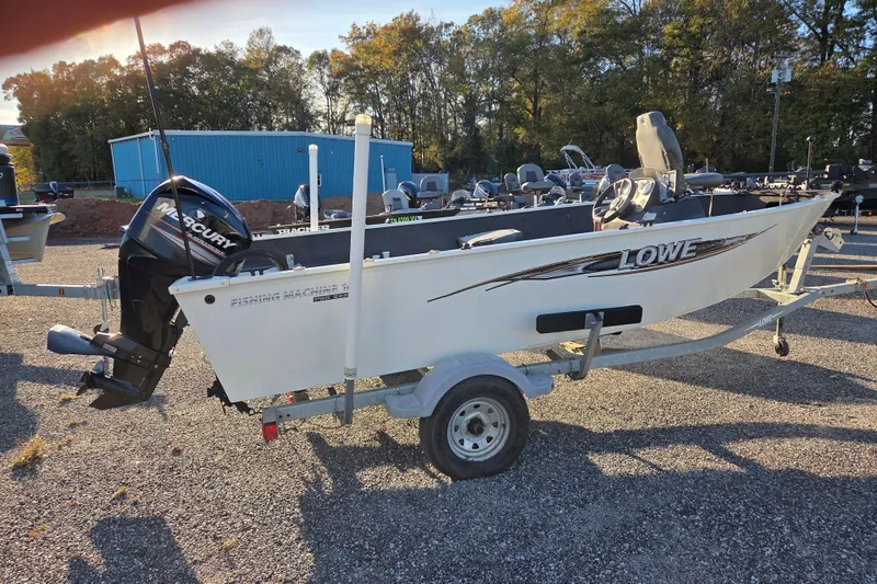 Slide: The Image of 2017 Lowe Fishing Machine 160 Pro boat on trailer, parked outdoors. - 2