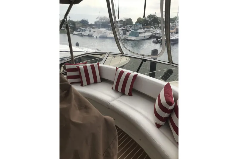 Slide: The Image of 1997 Silverton 352 Motor Yacht interior with striped cushions, overlooking marina. - 11