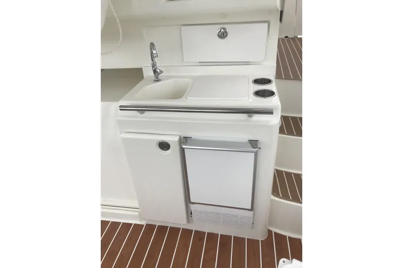 Slide: The Image of 1997 Silverton 352 Motor Yacht kitchenette with sink, faucet, and storage on wooden flooring. - 13