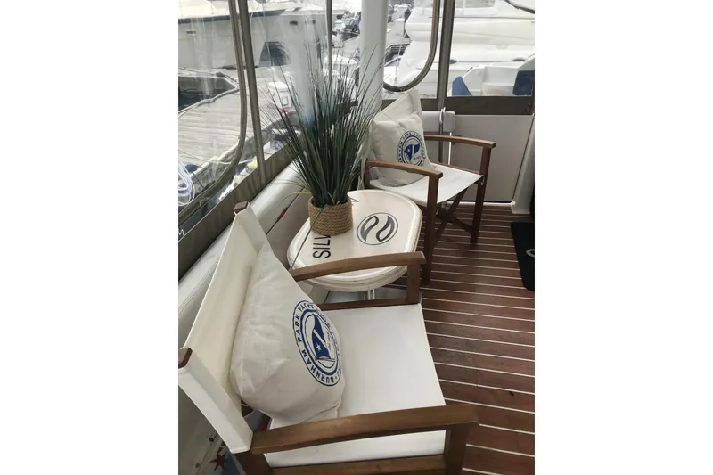 Slide: The Image of 1997 Silverton 352 Motor Yacht interior with chairs, cushions, and decorative plant. - 15