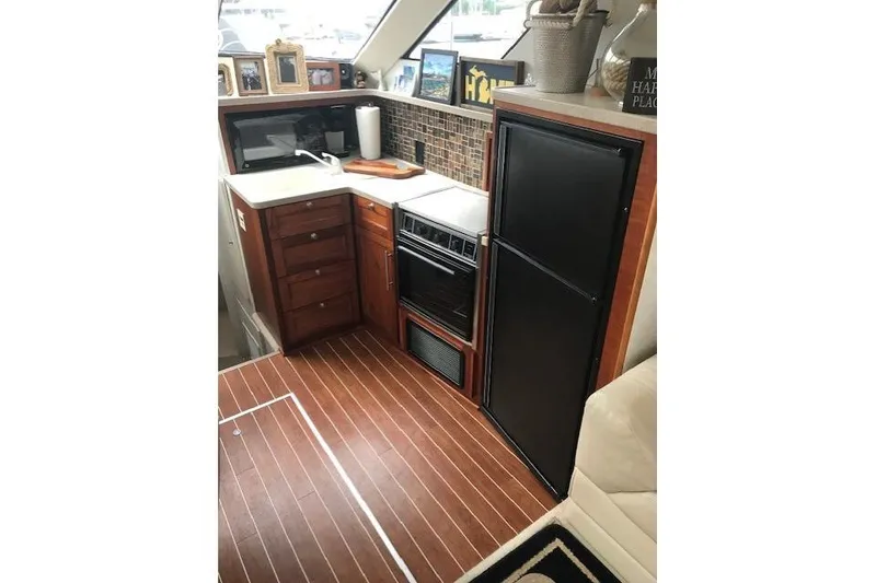 Slide: The Image of Interior of 1997 Silverton 352 Motor Yacht kitchen with wood flooring and appliances. - 20