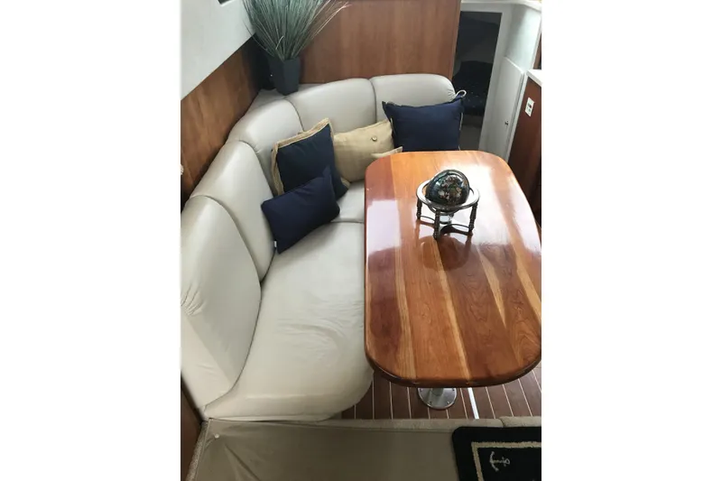 Slide: The Image of Luxurious interior of 1997 Silverton 352 Motor Yacht with elegant seating and wooden table. - 21
