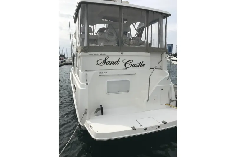 Slide: The Image of 1997 Silverton 352 Motor Yacht named "Sand Castle" docked in a marina. - 5