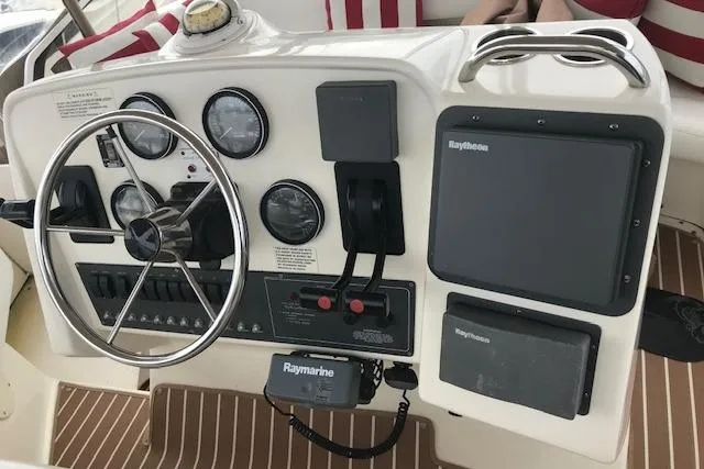 Slide: The Image of 1997 Silverton 352 Motor Yacht helm with steering wheel, gauges, and Raymarine navigation equipment. - 8